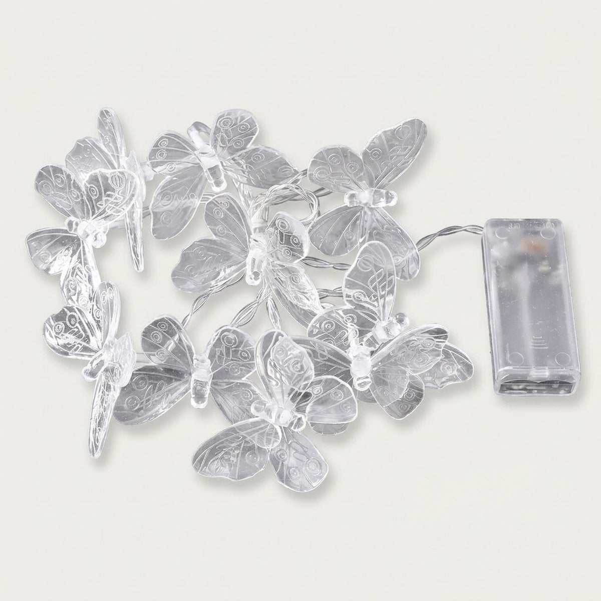 Unlit clear butterfly string lights with patterned wings and silver wire lie beside a transparent battery box on a white background.