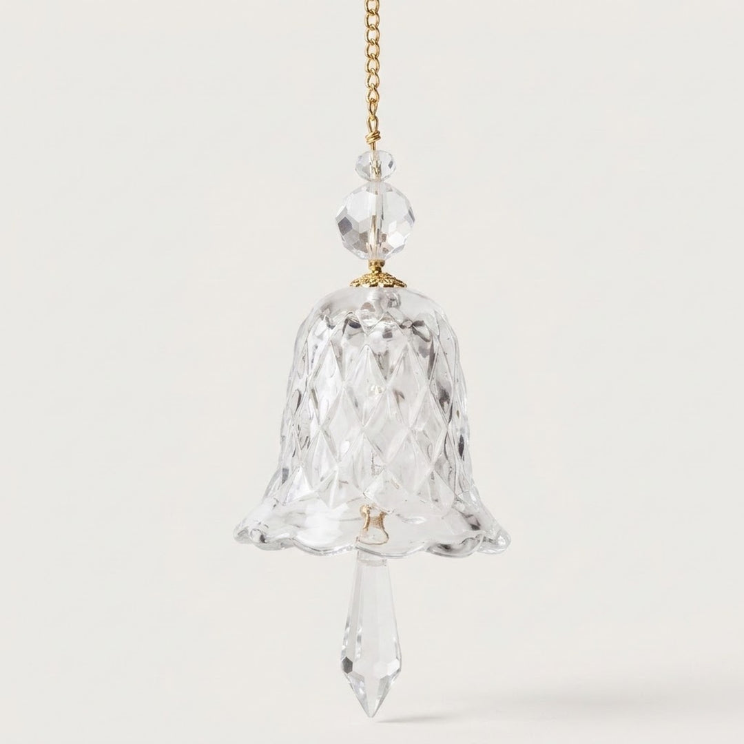 A clear bell-shaped glass suncatcher with a scalloped rim, two faceted beads, and a pointed drop hangs against a white background.