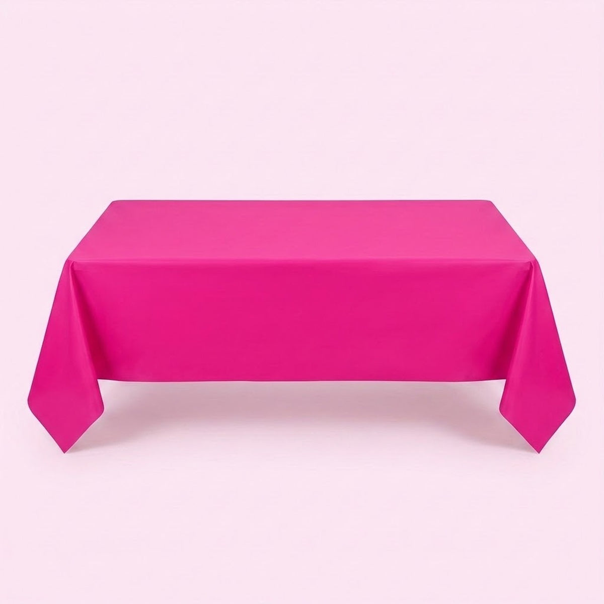 A hot pink tablecloth covers a rectangular table with long pointed corner folds against a pale pink background.