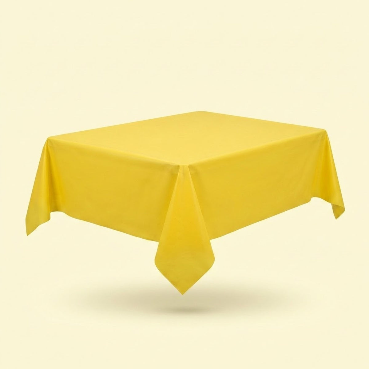 A yellow tablecloth drapes over a table viewed diagonally, with a pointed front corner against a pale yellow background.