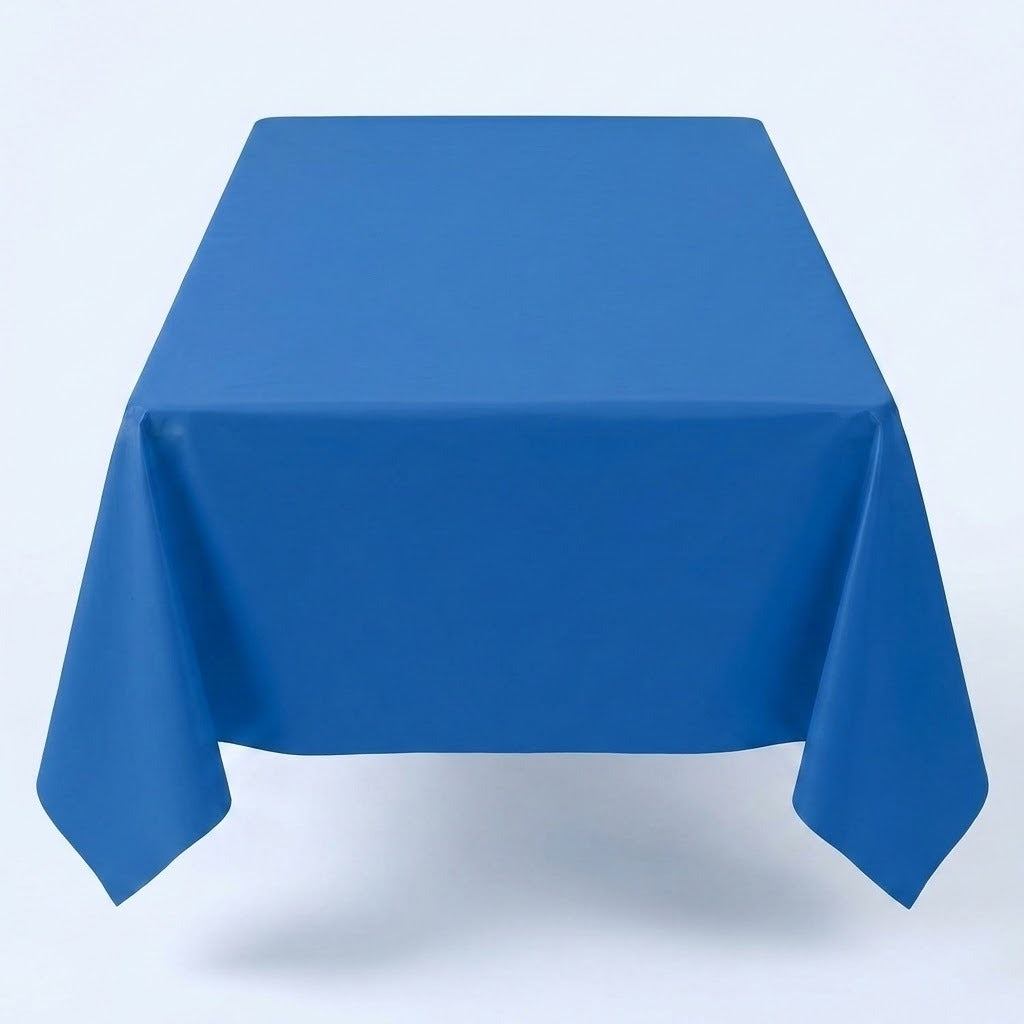 A blue tablecloth covers a rectangular table with long corners hanging down against a pale background.