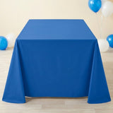A blue tablecloth drapes nearly to the pale wooden floor, with blue and white balloons against a cream wall.