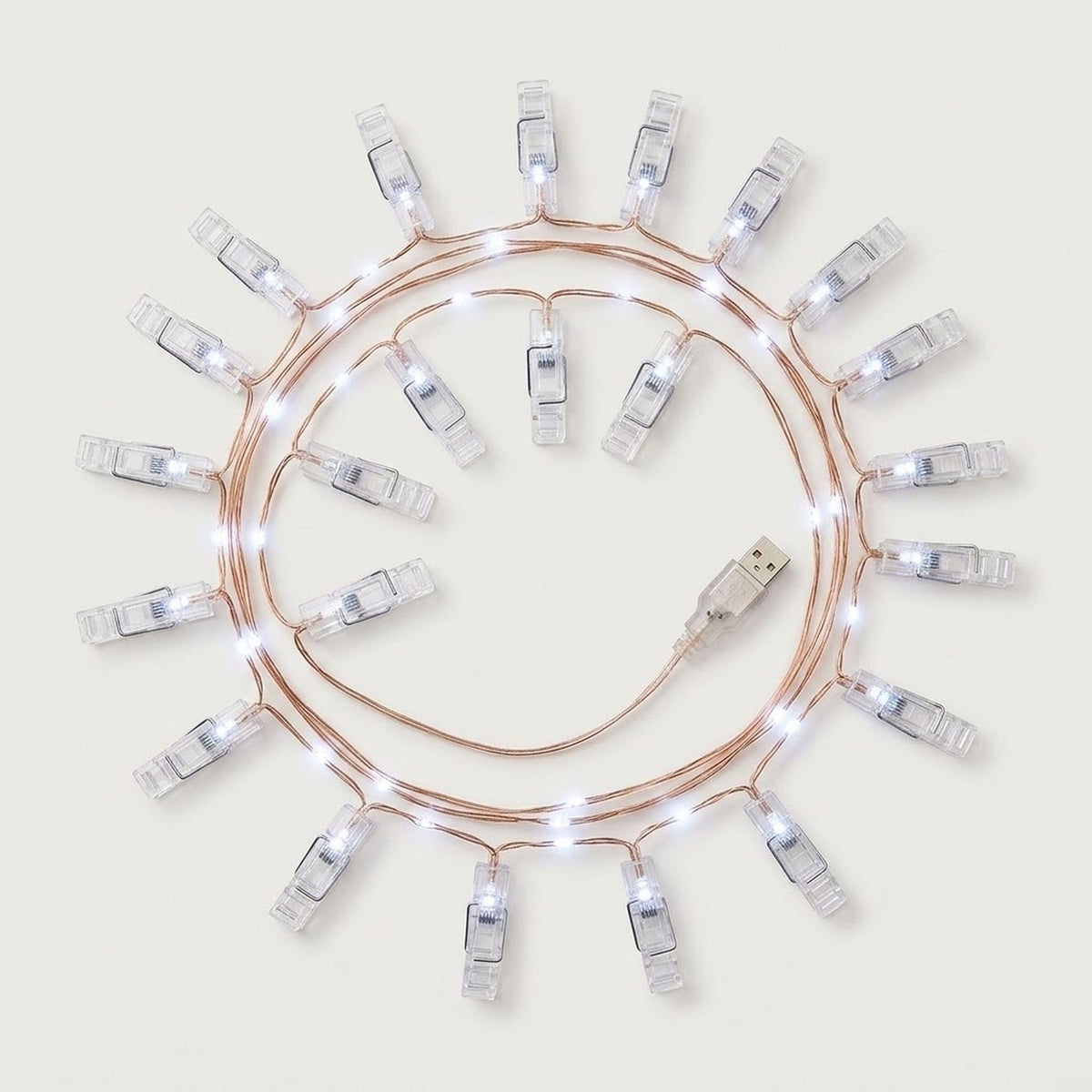 Cool white photo clip lighting with clear clips and copper-colored wire coils around a USB connector on a white background.
