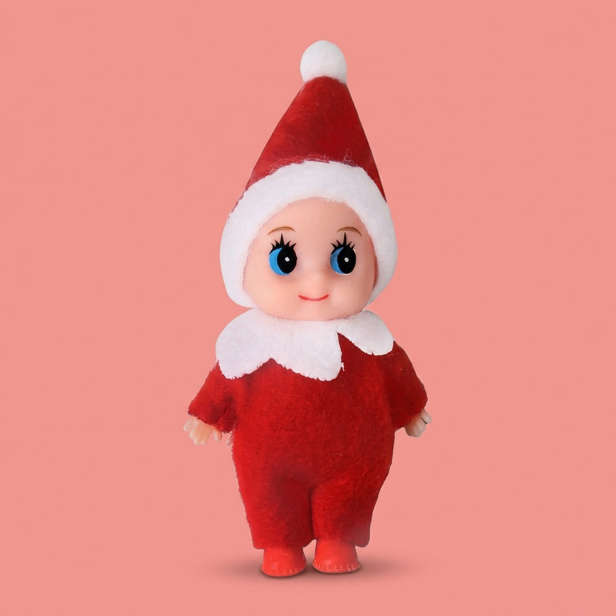 Elf doll wears a red fabric outfit, white-trimmed pointed hat, white collar, and red shoes against a coral background.