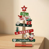 Wooden tabletop Christmas decoration with red and green message slats and a red star topper stands on a light wood surface.