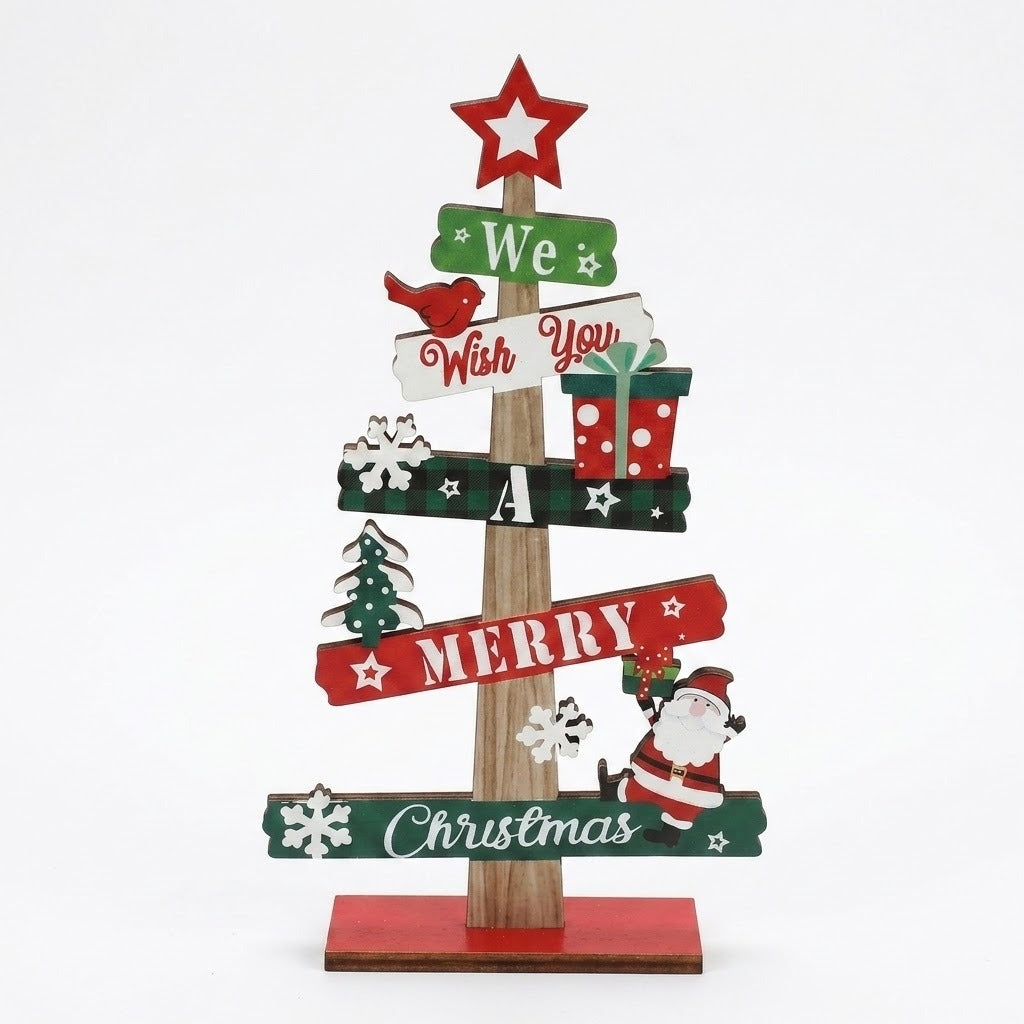 Wooden tabletop Christmas decoration with red, green and white message signs, a star topper, Santa and snowflakes against a white background.