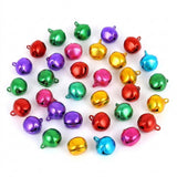Red, green, purple, pink, blue and gold jingle bells with hanging loops are spread across a white background.