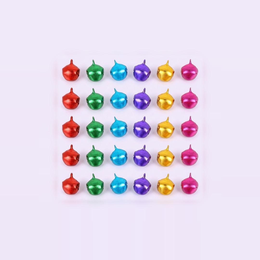 Red, green, blue, purple, gold, and pink metallic jingle bells sit in five rows of six on a pale background.