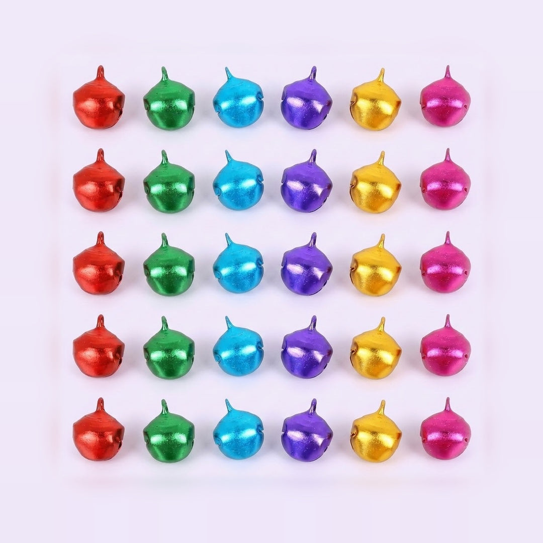Thirty metallic jingle bells in red, green, blue, purple, gold, and pink form five rows on a pale background.
