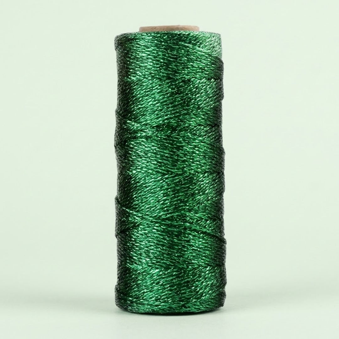 Shiny green twisted craft cord is wound around an upright cardboard spool against a pale green background.