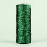 Shiny green twisted craft cord is wound around an upright cardboard spool against a pale green background.