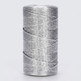 A silver metallic craft cord spool stands upright against a light grey background, showing tightly wound, overlapping strands.