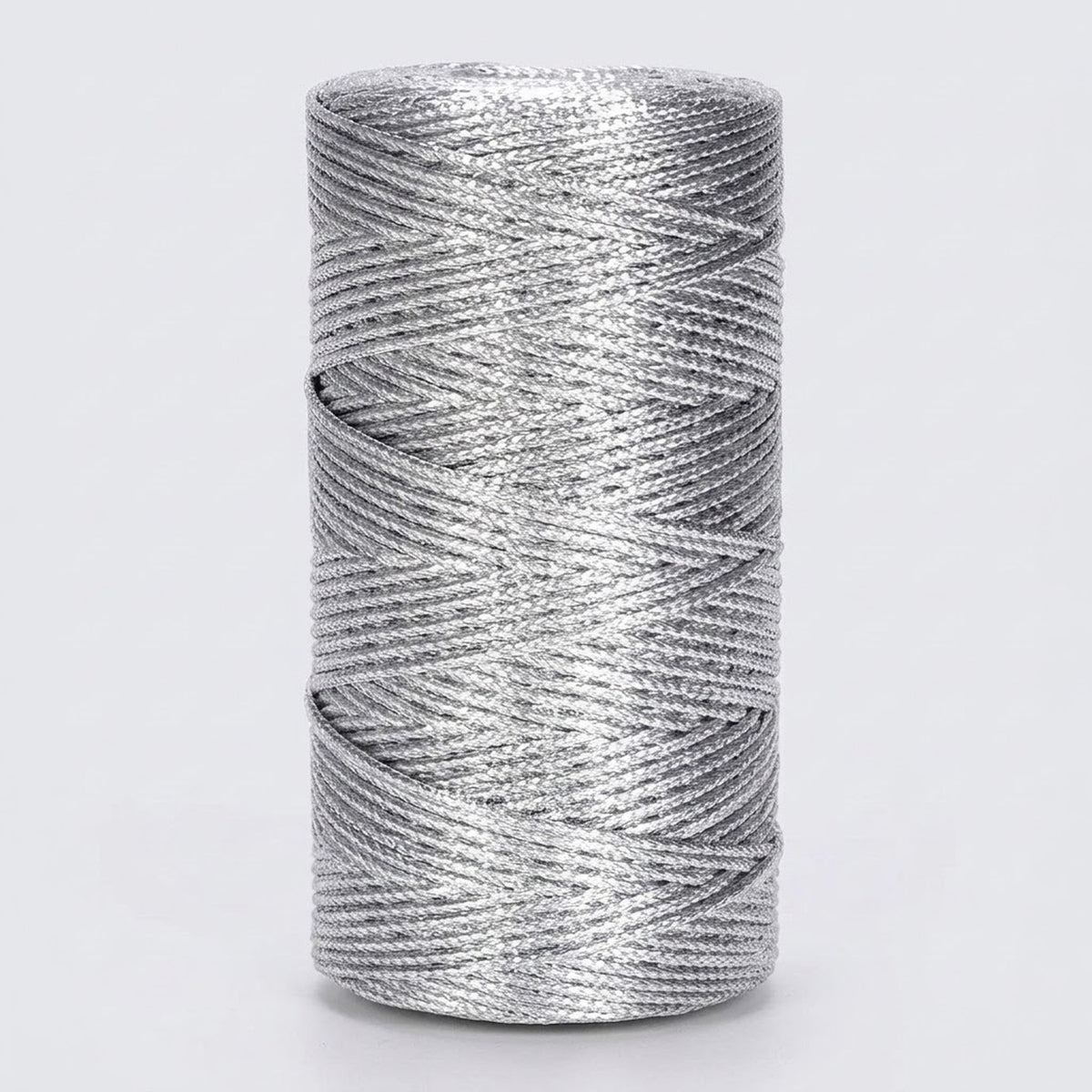 A silver metallic craft cord spool stands upright against a light grey background, showing tightly wound, overlapping strands.
