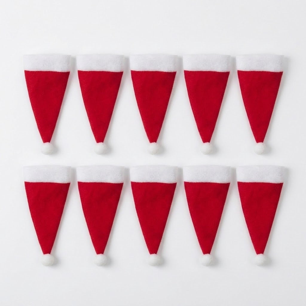Ten red Santa hat cutlery holders with white cuffs and pompoms lie in two rows of five on a white background.