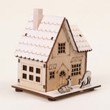Pale wooden christmas house with a chimney, scalloped roof, cutout windows, and two deer figures on a rectangular base against a cream background.