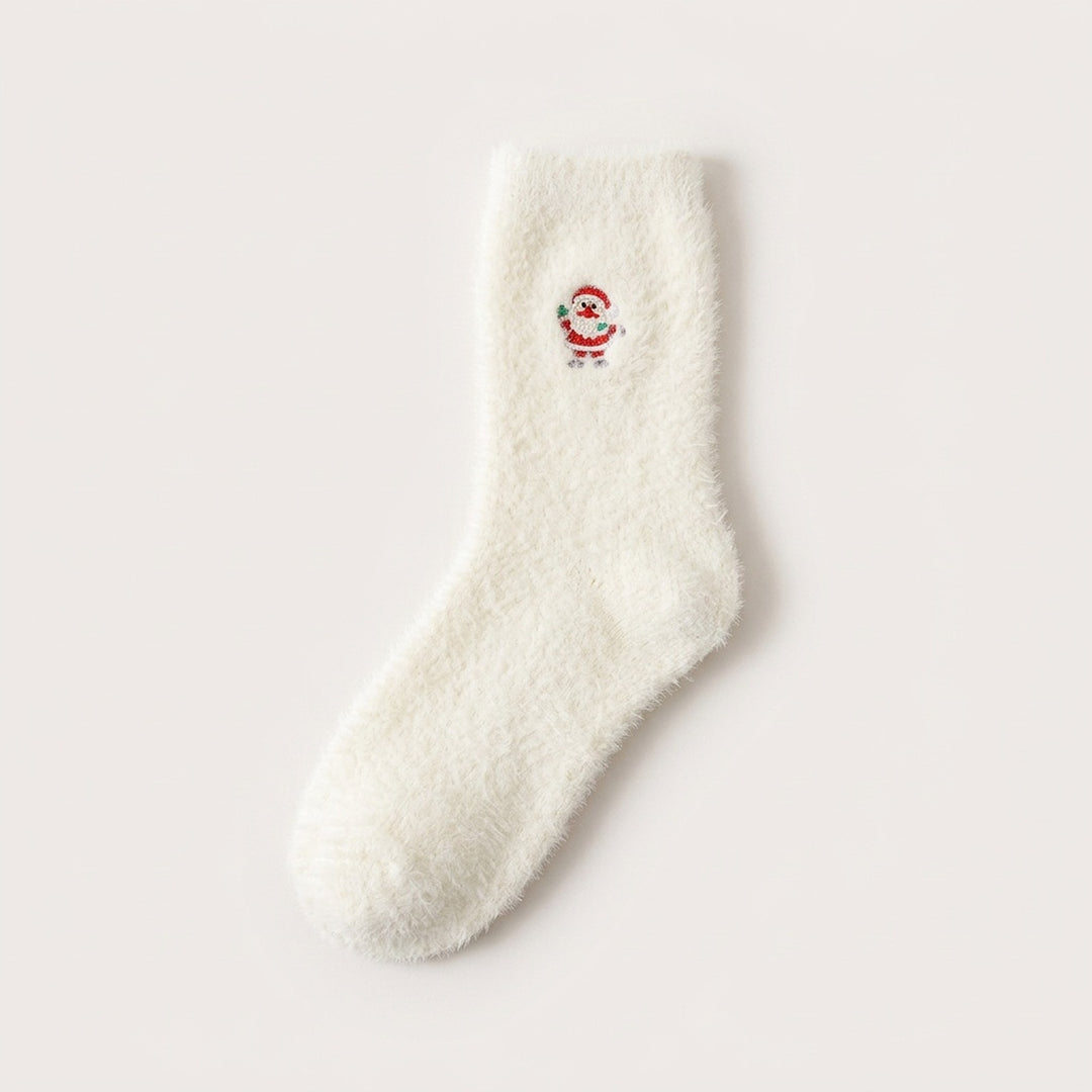 A fluffy white sock with a small Santa Claus motif in red and white lies flat on a pale background.