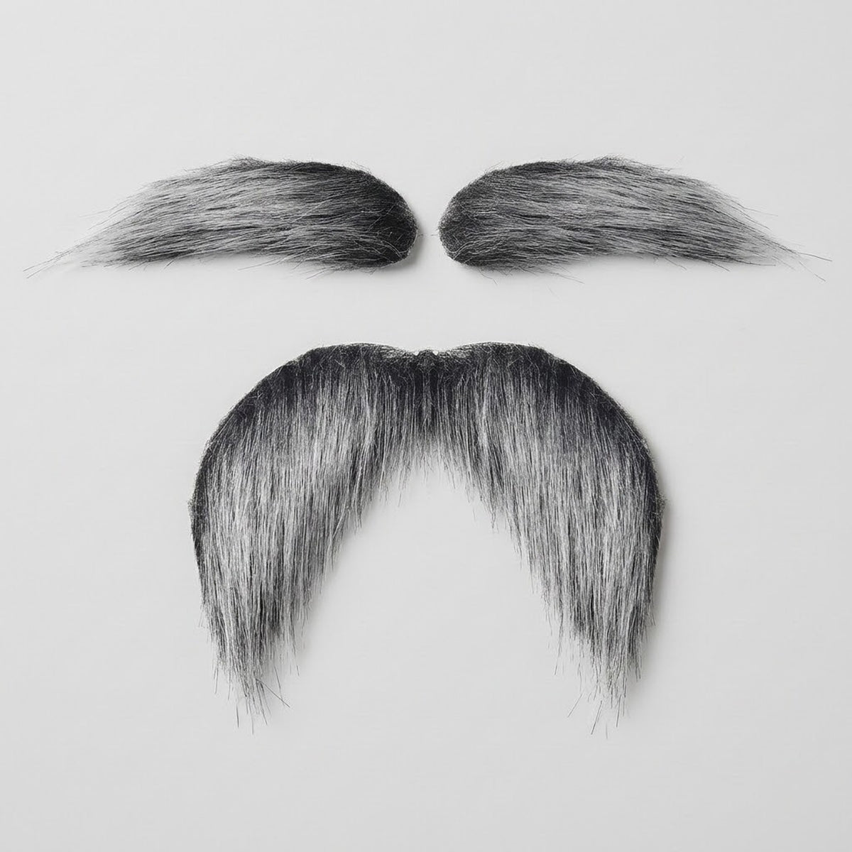 Salt-and-pepper costume facial hair includes two eyebrows and a drooping mustache with black and silver strands on a light gray background.