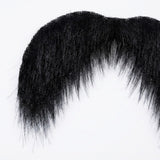 Black costume facial hair appears in close-up, showing dense mustache fibers and tapered downward ends against a white background.