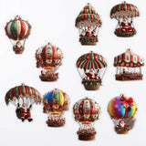 Ten colourful timber Christmas ornaments depicting Santa beneath balloons and parachutes are arranged on white, each with a hanging hole.