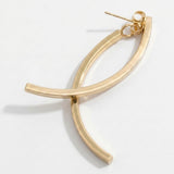 A gold-tone drop earring lies on white, showing two crossing curved bars, a stud post, and butterfly backing.