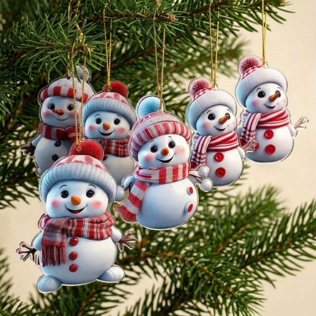 Six flat acrylic snowman Christmas ornaments with red patterned scarves hang from gold cords among green branches against a cream background.