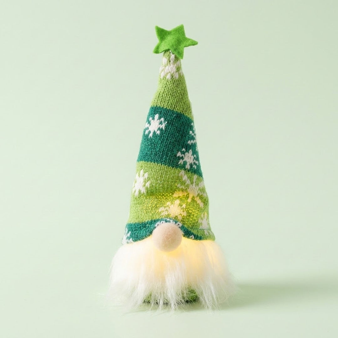 Glowing Christmas gnome wears a green knitted snowflake hat with a green star above its white beard against a pale green background.
