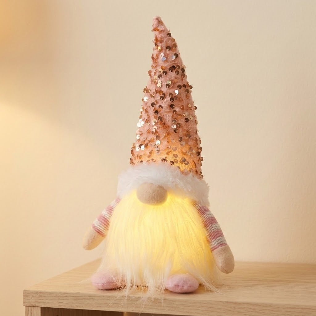 A Christmas gnome with a pink sequined hat, checked sleeves and glowing white beard stands on a wooden cabinet against beige.