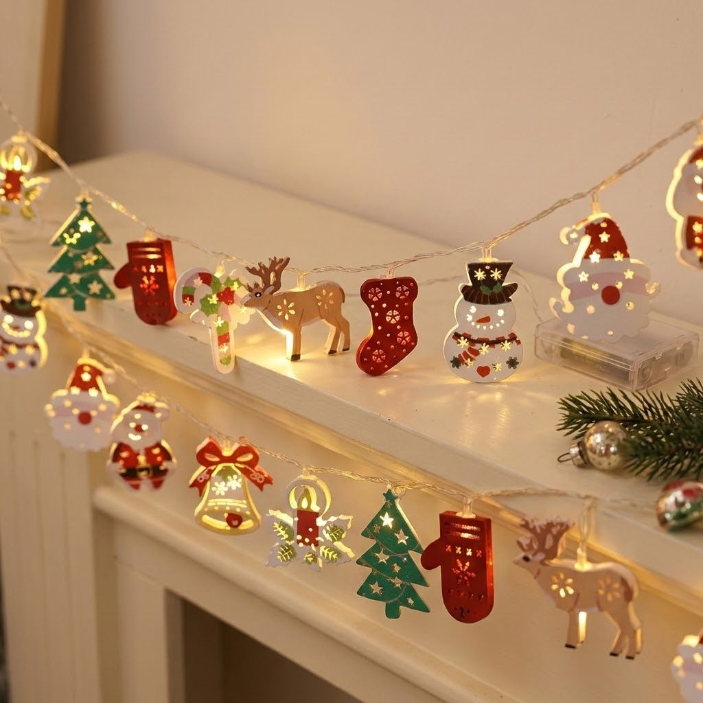 A warm white string light with colorful Christmas ornaments drapes across a white mantel beside evergreen branches and silver baubles.