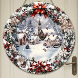 Round wood Christmas sign with flat snowy village artwork, green foliage, and red bows hangs against a cream paneled door.