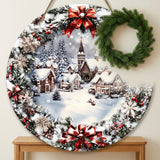 Round wood Christmas sign with snowy town artwork hangs above a wooden console, partially overlapped by a separate green wreath.