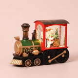 Red and green Christmas train decoration with gold-tone details showing a snowman and Christmas tree amid glowing snowflake effects.
