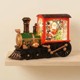 Red and green Christmas train decoration with gold trim and an illuminated Santa compartment rests on a pale wooden shelf against a cream wall.