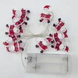 Unlit red and white Santa string lights connect to an empty transparent battery box on a white background.