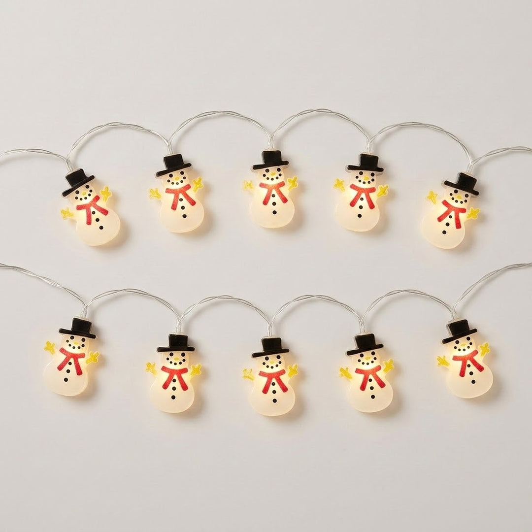 White snowman string lights with black hats, red scarves, and yellow hands glow in two rows against a light gray background.