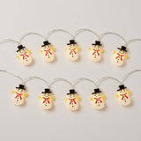 White snowman string lights with black hats, red scarves, and yellow hands glow in two rows against a light gray background.