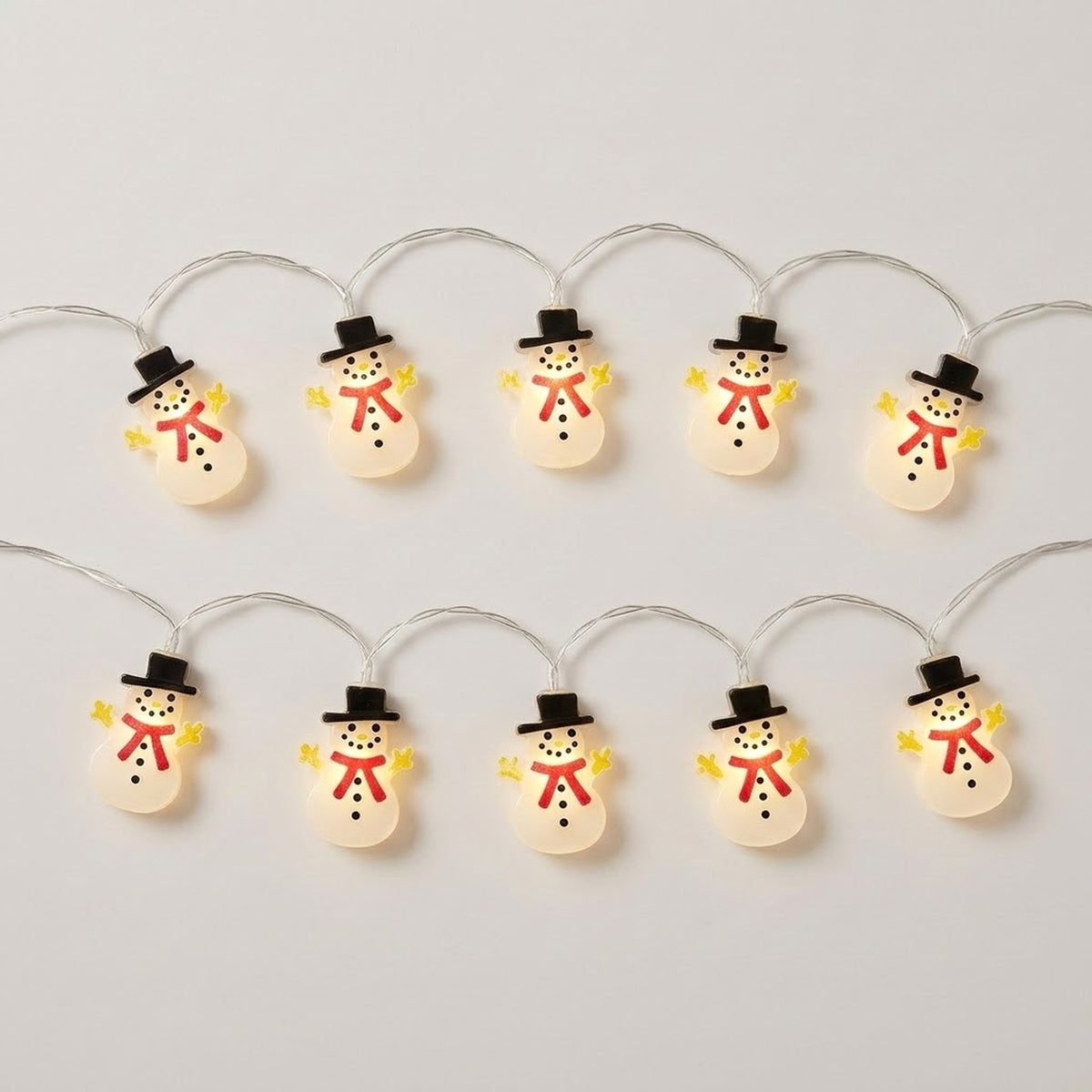 White snowman string lights with black hats, red scarves, and yellow hands glow in two rows against a light gray background.