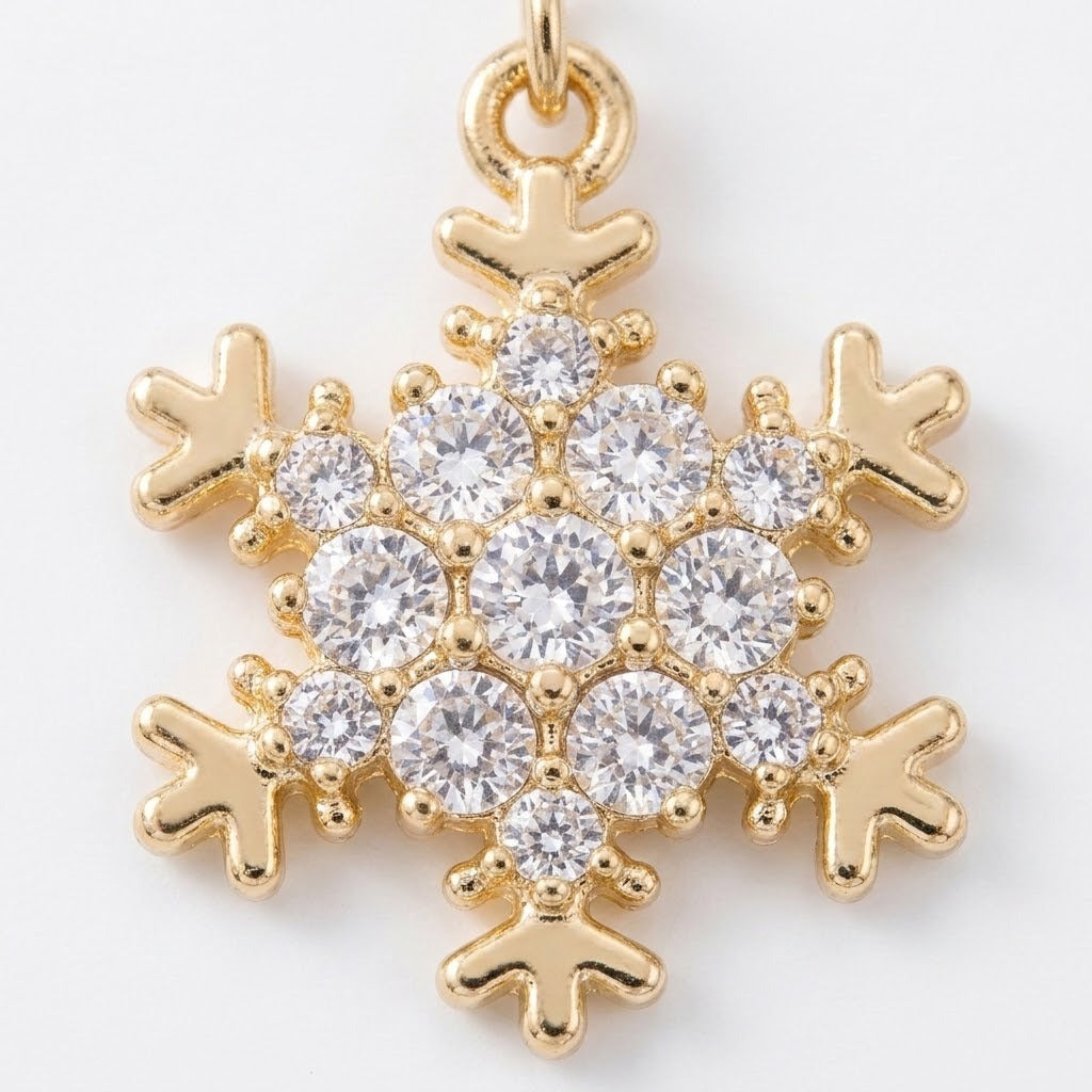 A snowflake drop earring detail shows clear round rhinestones and gold-colored outlines against a white background.