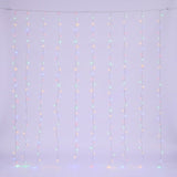 Multicolored curtain lights glow along clear hanging strands against a pale background.