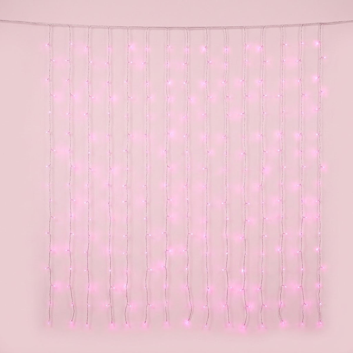 Pink curtain lights hang in vertical strands from a clear horizontal cable against a pale pink background.