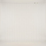 Warm white curtain lights hang in vertical strands against an off-white background, with connectors visible along the top cable.