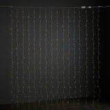 Small white curtain lights hang against a dark wall, with clear wiring and inline connectors visible along the top.