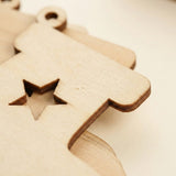 Overlapping pale wooden ornament blanks show a star cutout, hanging hole, visible grain, and dark edges against a cream background.