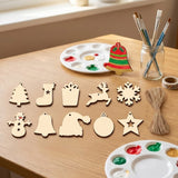 Pale wooden ornament blanks lie on a craft table beside twine, paint palettes, brushes, and a painted red and green bell.