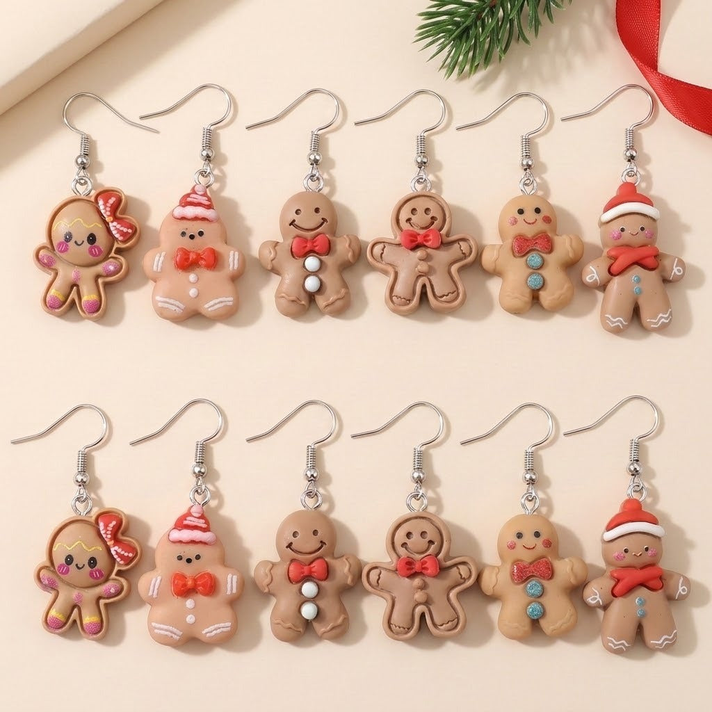 Twelve tan gingerbread-character drop earrings with silver fishhooks lie in two rows on a cream surface beside a fir sprig and red ribbon.