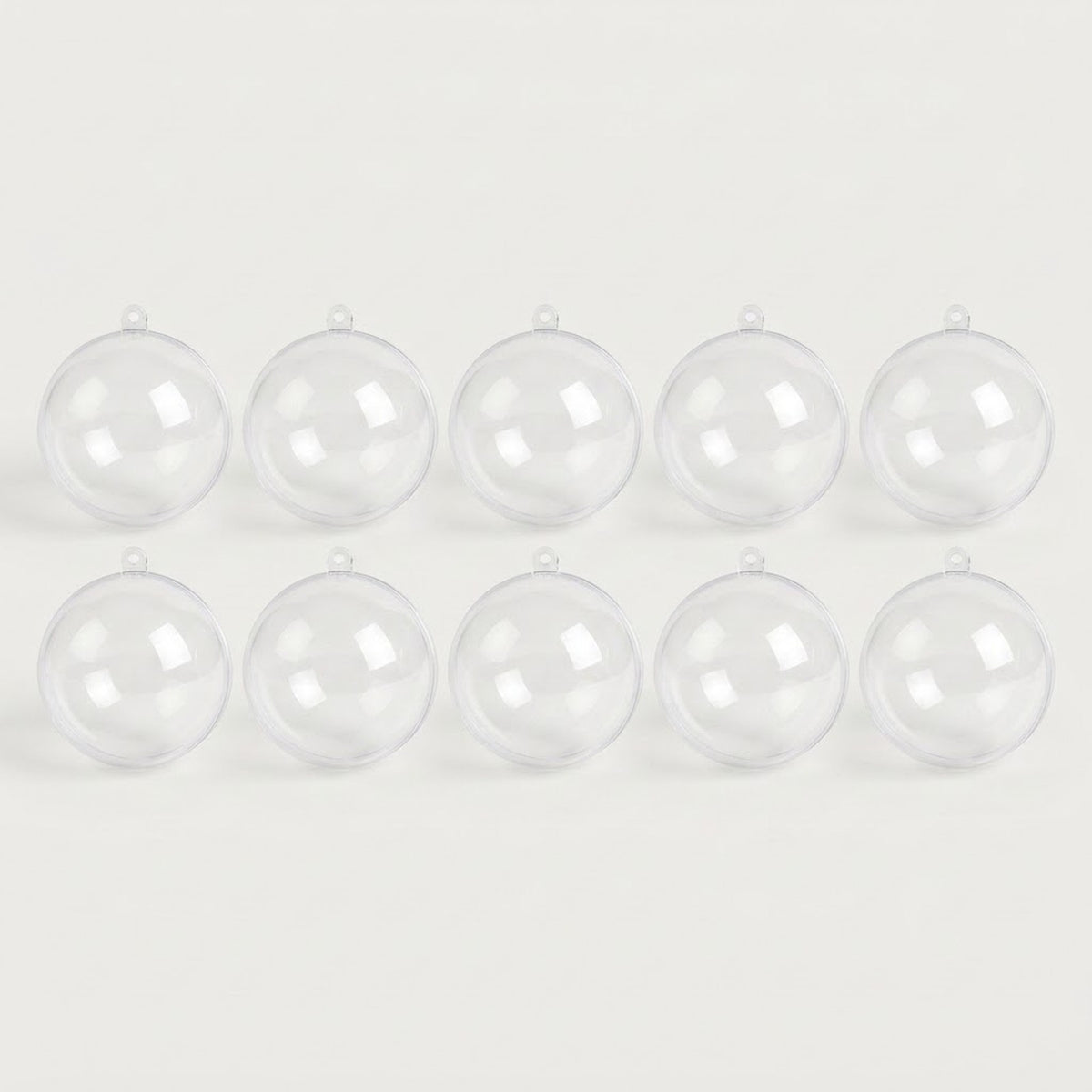 Ten clear plastic fillable ornaments with hanging loops form two rows of five across a white background.