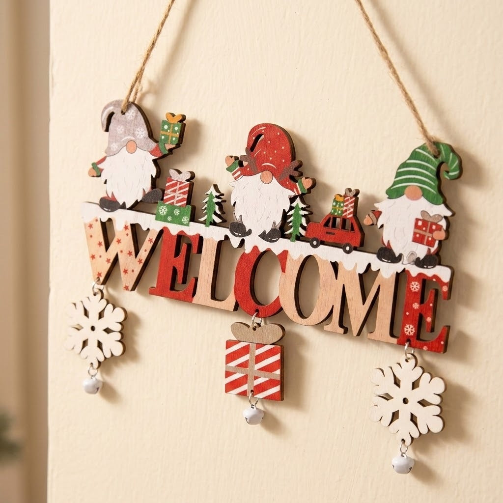 Red and natural wooden Christmas ornament with gnomes, WELCOME letters, snowflakes, and bells hangs at an angle against a cream wall.