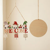 Wooden Christmas ornament with colorful gnomes, WELCOME lettering, snowflakes, and bells hangs beside a plain wooden disc against a cream background.