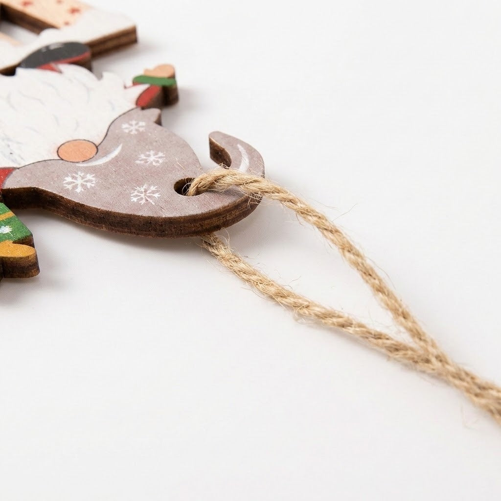 A close-up of a wooden Christmas ornament shaped like Santa's sleigh, featuring white snowflake designs on a brown wood finish, with a natural jute hanging string, set against a plain white background.