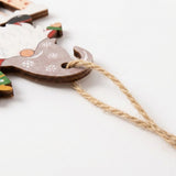 A close-up of a wooden Christmas ornament shaped like Santa's sleigh, featuring white snowflake designs on a brown wood finish, with a natural jute hanging string, set against a plain white background.