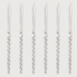 Six clear acrylic twisted icicle Christmas ornaments with white hanging ribbons are evenly spaced against a white background.